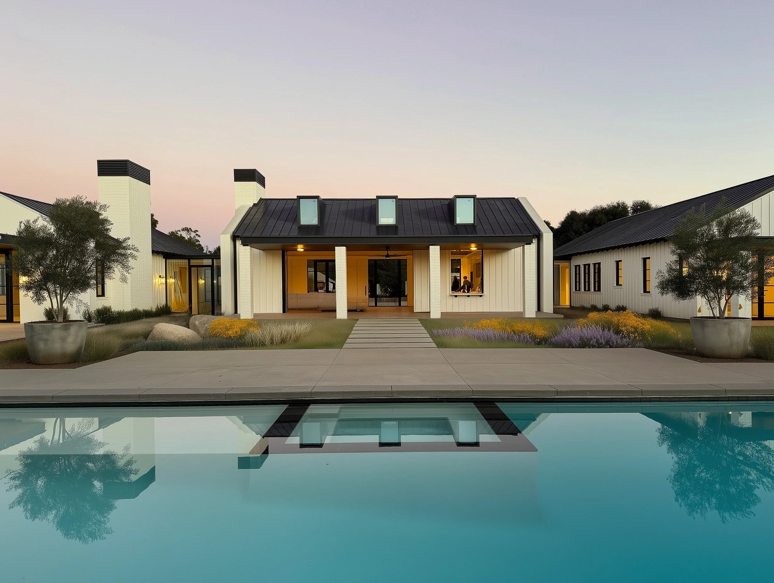 Modern two-story house with large glass windows and geometric design, illuminated at dusk.