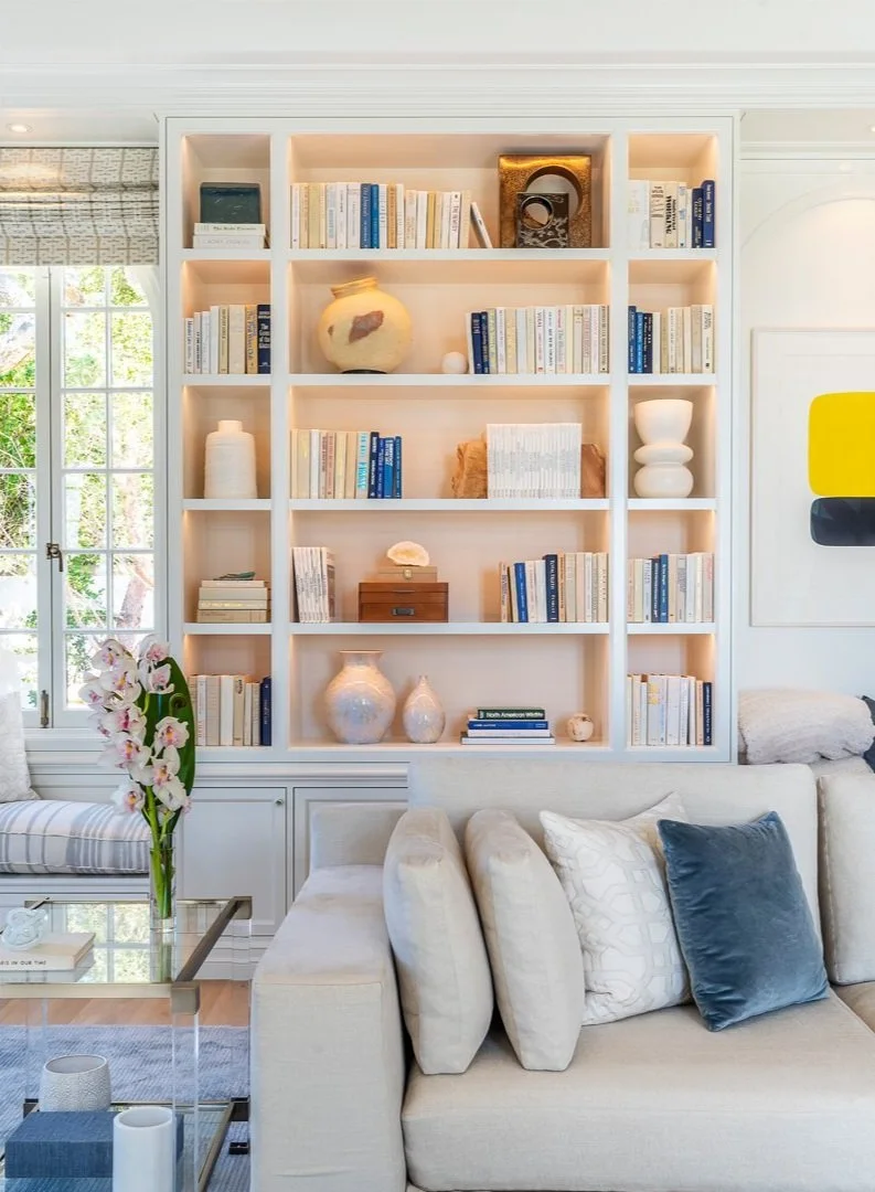 Living room with bookshelf, books, vases, sofa, and decorative pillows