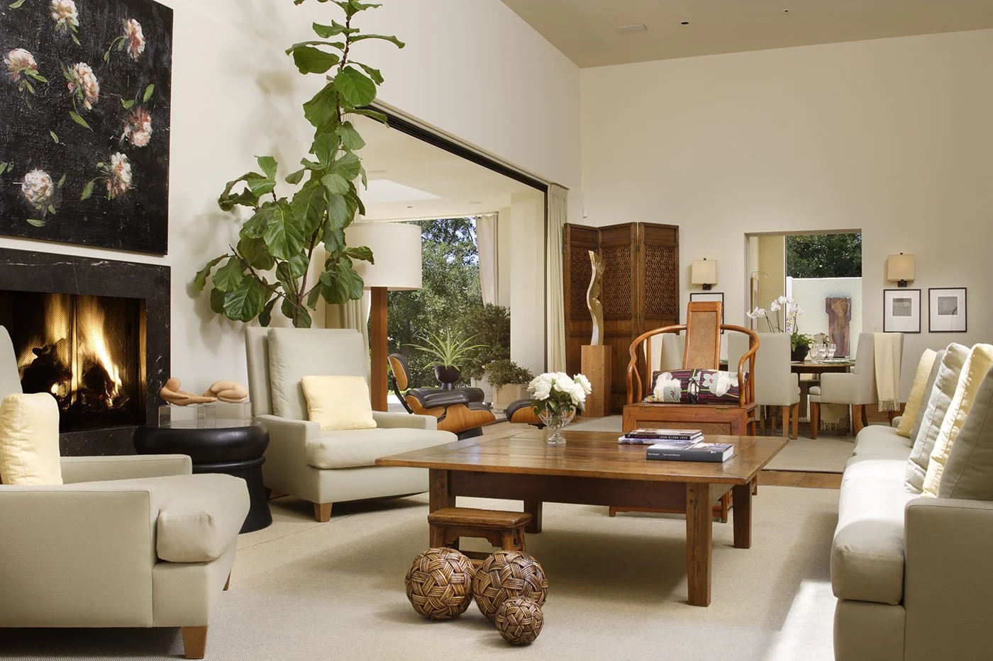 Warm living room with natural wood furniture, woven accents, and neutral tones, featuring a cozy fireplace, perfect for relaxing.